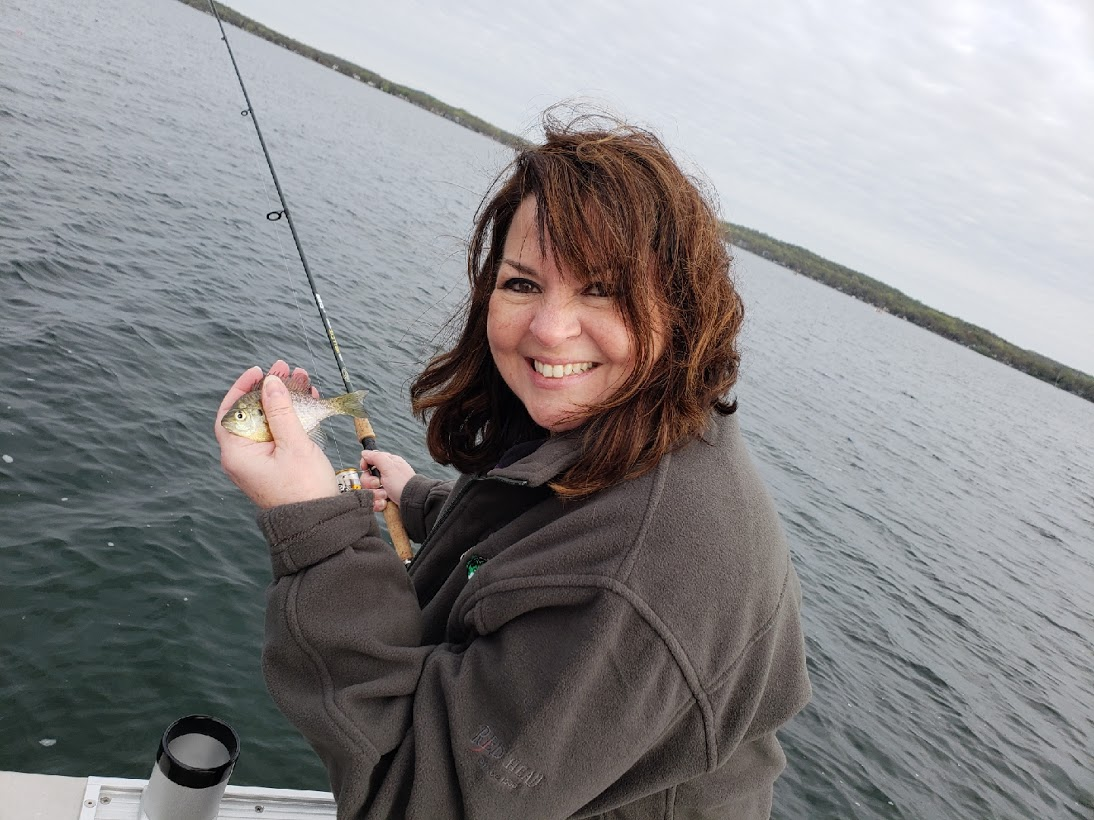 Senator Susan Kent at the Governor's Fishing Opener with a tiny fish.